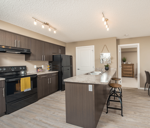 A kitchen with a black stove top oven and a black refrigerator.