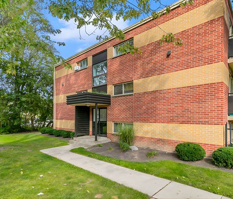 A red brick building with a black door and windows.