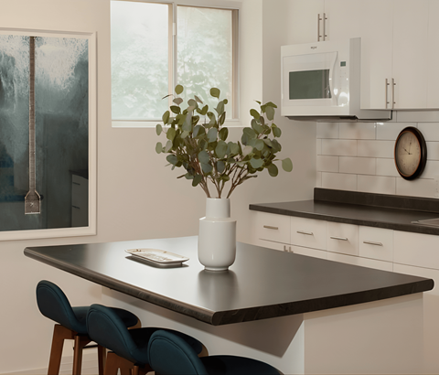 A kitchen with a table and chairs.
