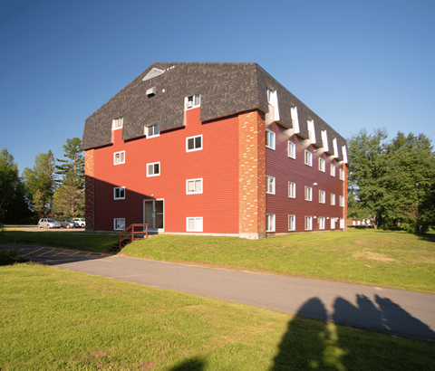 A red brick building with a black roof and white trim.