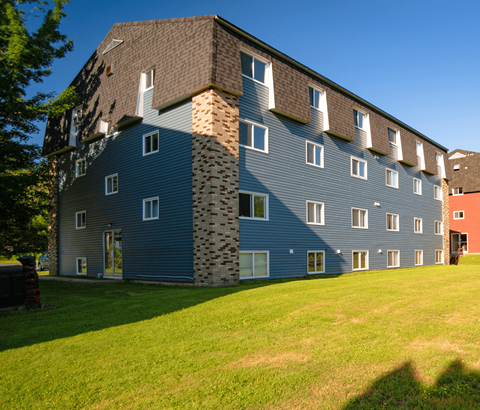 A large building with a mix of blue and grey siding.
