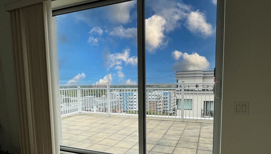 a balcony with a view of a blue sky and clouds