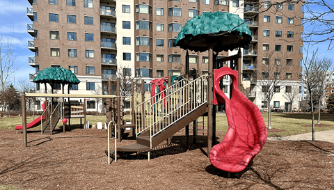 a playground with a slide in front of a building