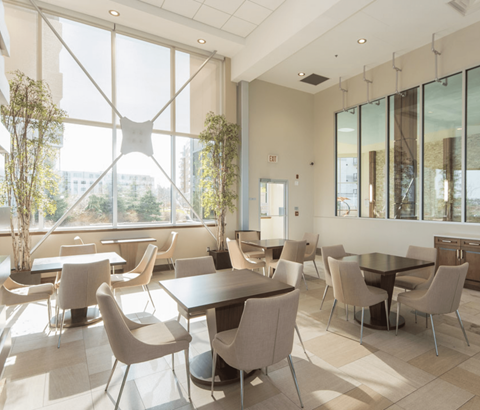 A modern dining room with large windows and a view of the city.