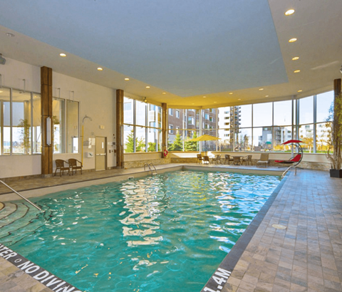 A large indoor swimming pool with a "No Diving" sign.