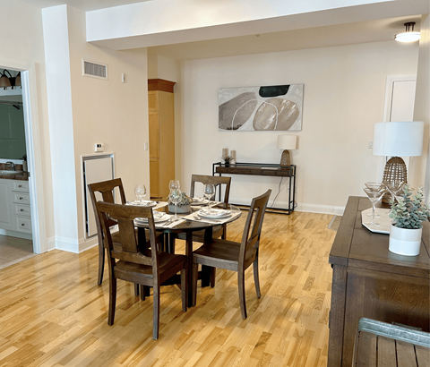 A dining room with a wooden table and chairs.