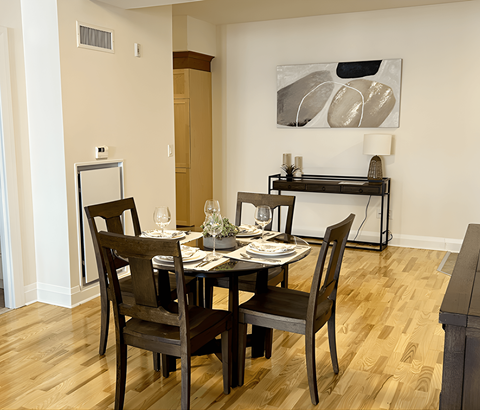 A dining room with a wooden table and chairs.
