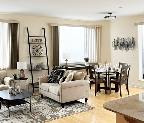 A living room with a white sofa, a black table, and a wooden floor.