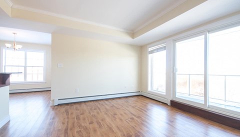 A large empty room with wooden floors and white walls.