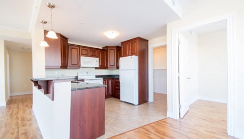 A kitchen with wooden cabinets and a white refrigerator.
