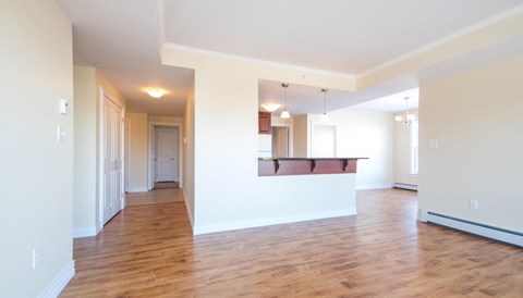 A large empty room with wooden floors and white walls.