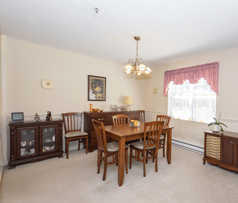 A dining room with a wooden table and chairs.