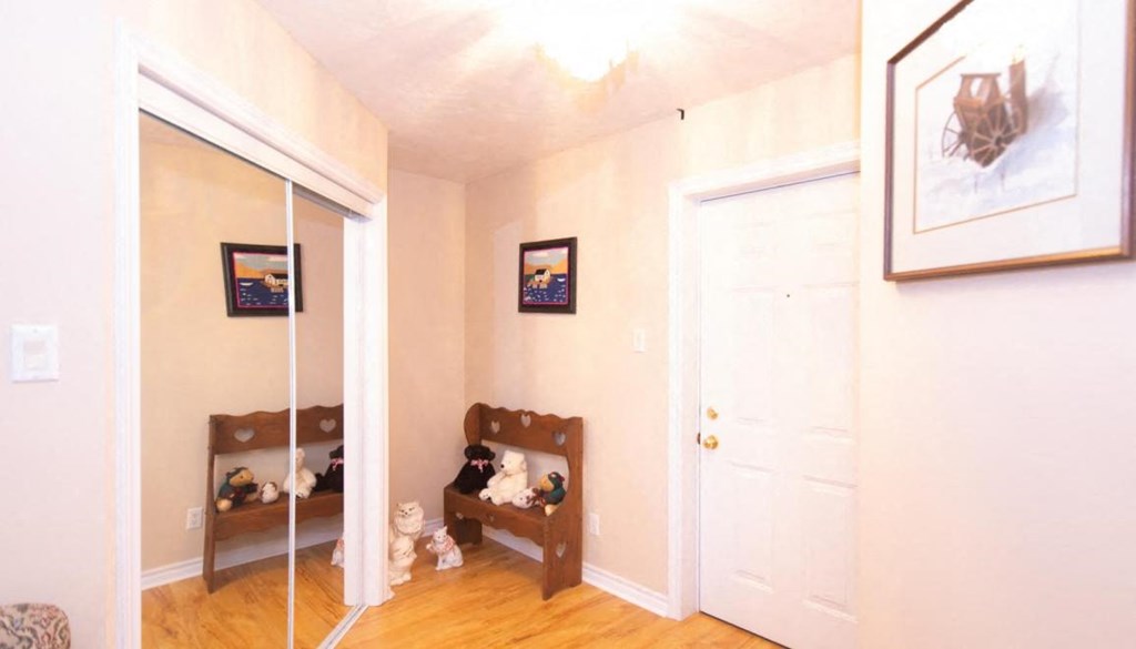 a bedroom with a mirror and a small closet