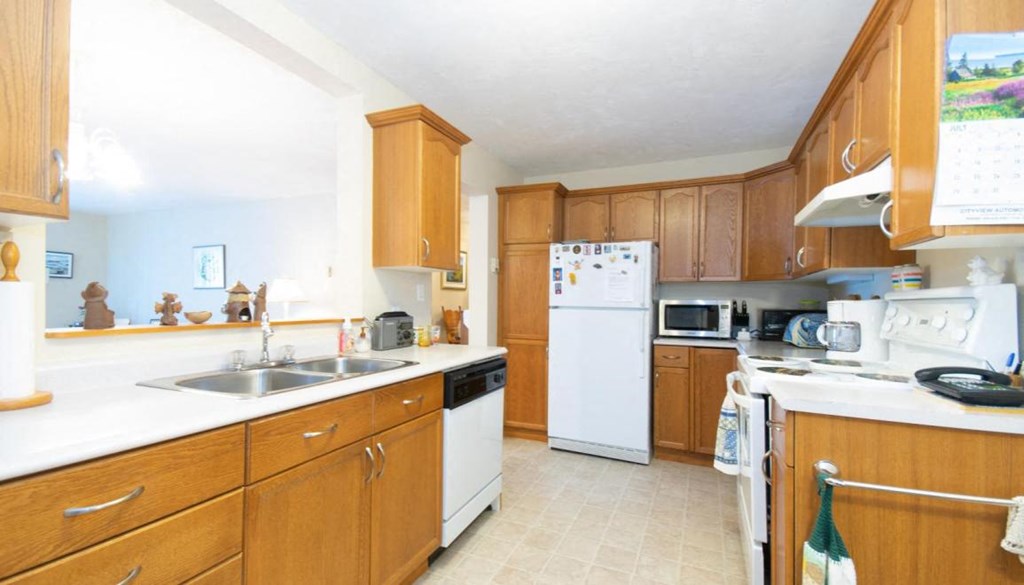 a kitchen with white appliances and wooden cabinets