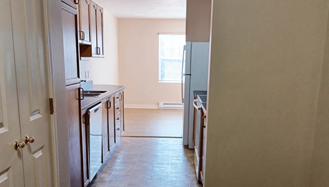 A kitchen with wooden cabinets and a white refrigerator.