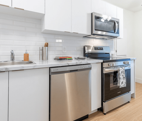 A modern kitchen with a stainless steel dishwasher and oven.