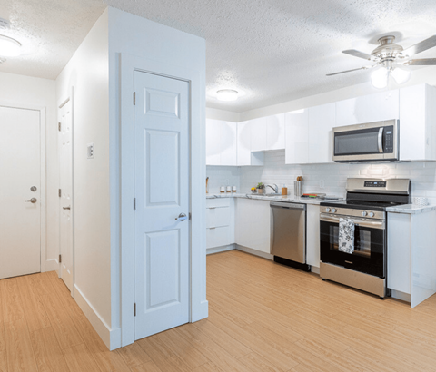 A kitchen with a white door and appliances.