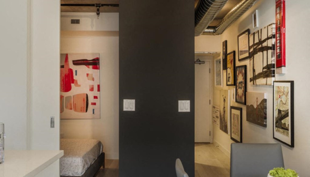 a room with a black wall and paintings and a door