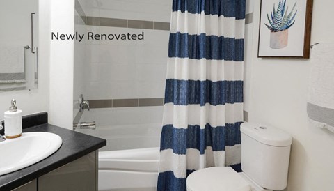 a white bathroom with a blue and white striped shower curtain