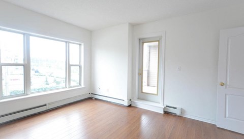 an empty living room with white walls and wood floors