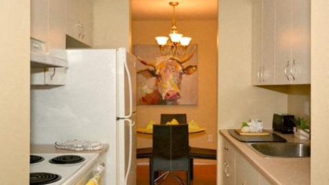 a kitchen with a white refrigerator and a dining table
