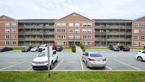 A parking lot with cars and a building in the background.
