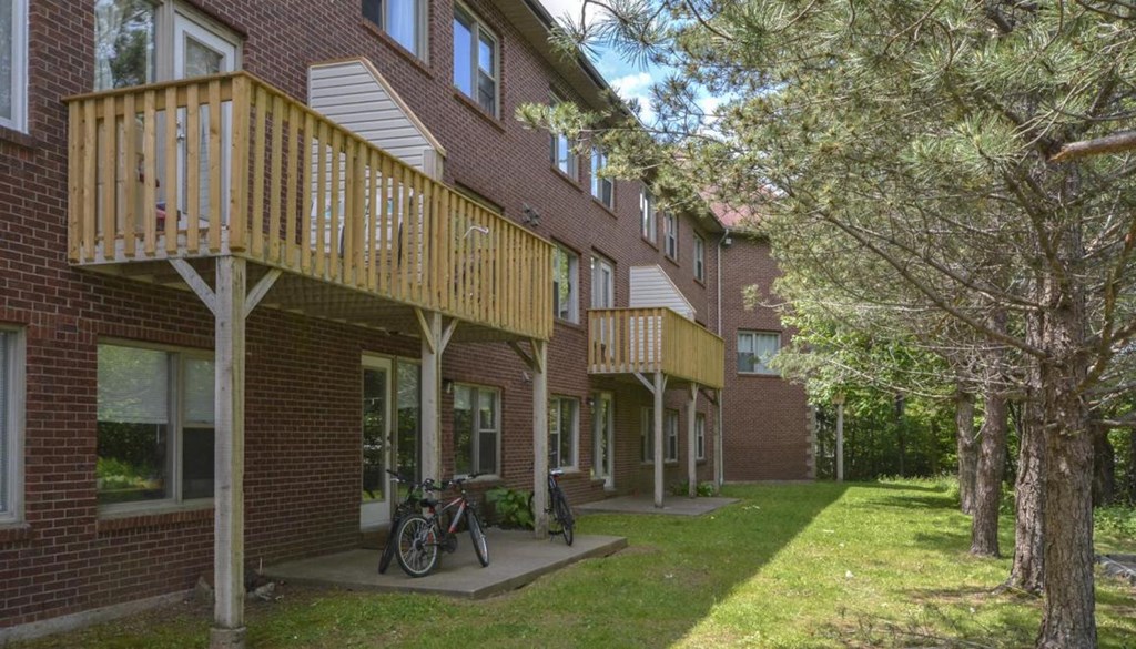 a brick apartment building with a balcony and a bike parked in the yard