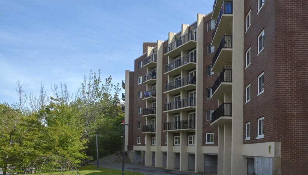 A large red brick building with balconies and windows.