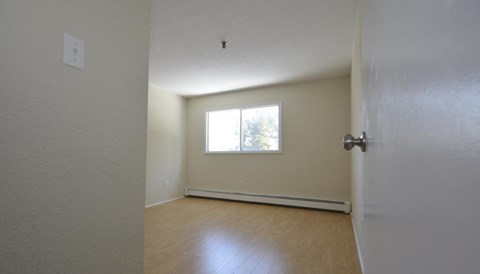 A room with a door, a window, and a light switch.