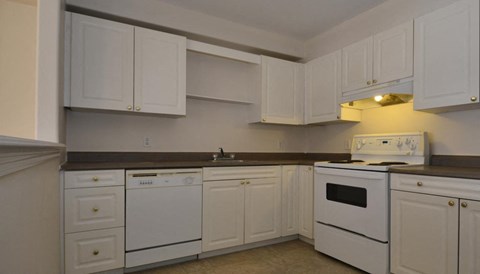 A kitchen with white cabinets and appliances.
