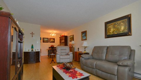 A living room with a grey couch and a coffee table with a floral design.