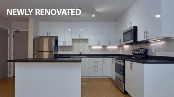 a kitchen with white cabinets and black counter tops