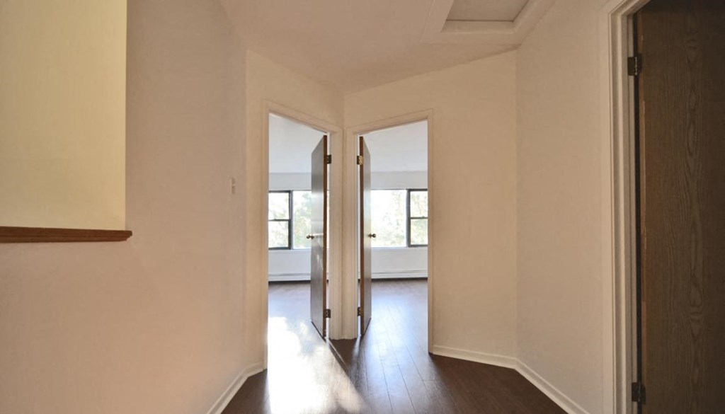 an empty room with two doors and a wood floor