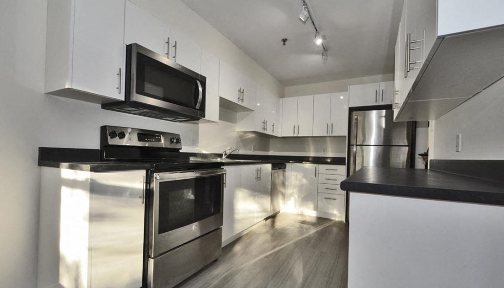 a kitchen with stainless steel appliances and white cabinets
