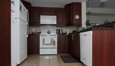 A kitchen with brown cabinets and a white fridge.