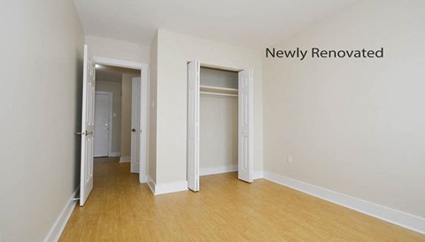 A newly renovated room with white walls and wooden floors.