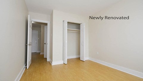 A newly renovated room with white walls and wooden floors.