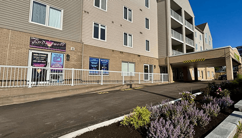 A parking lot in front of a multi-story apartment building.