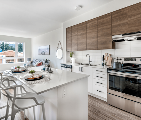 A modern kitchen with a dining table set for two.