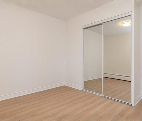 A room with a sliding glass door and wooden flooring.