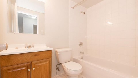 A white bathroom with a toilet, sink, and tub.