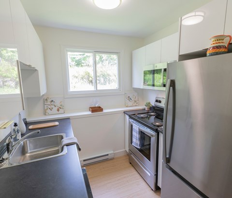 A modern kitchen with a stainless steel refrigerator and oven.