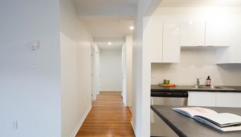 A kitchen with a black counter top and white cabinets.