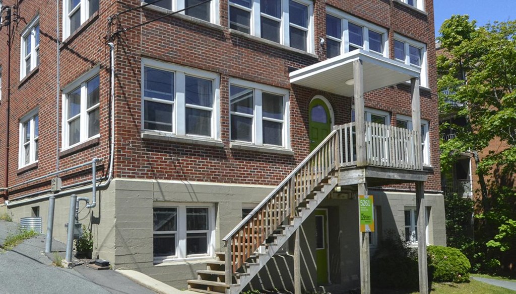 a brick apartment building with a wooden staircase