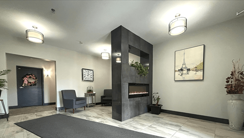 a lobby with a fireplace and two chairs