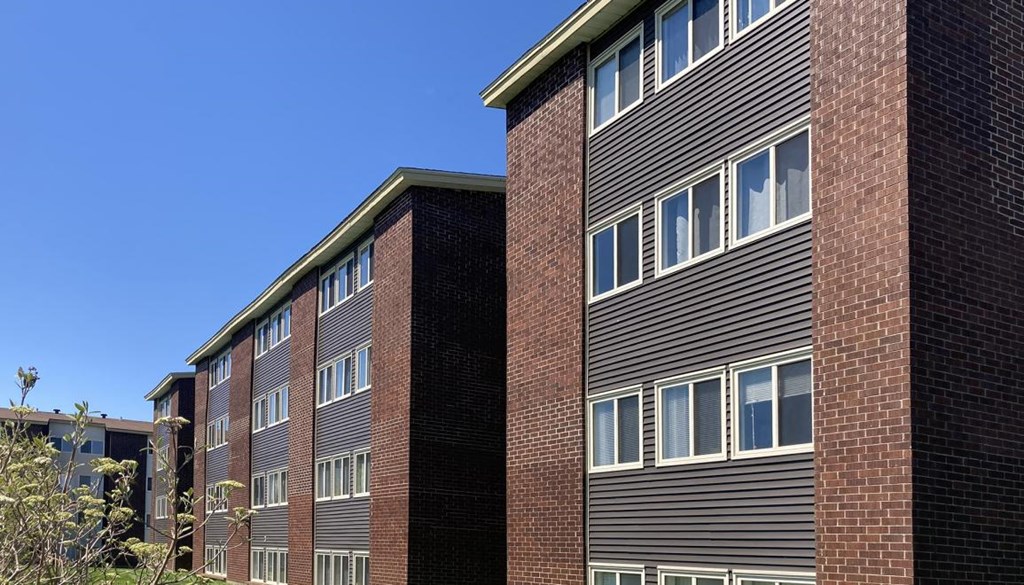 Two buildings with windows and a clear blue sky.