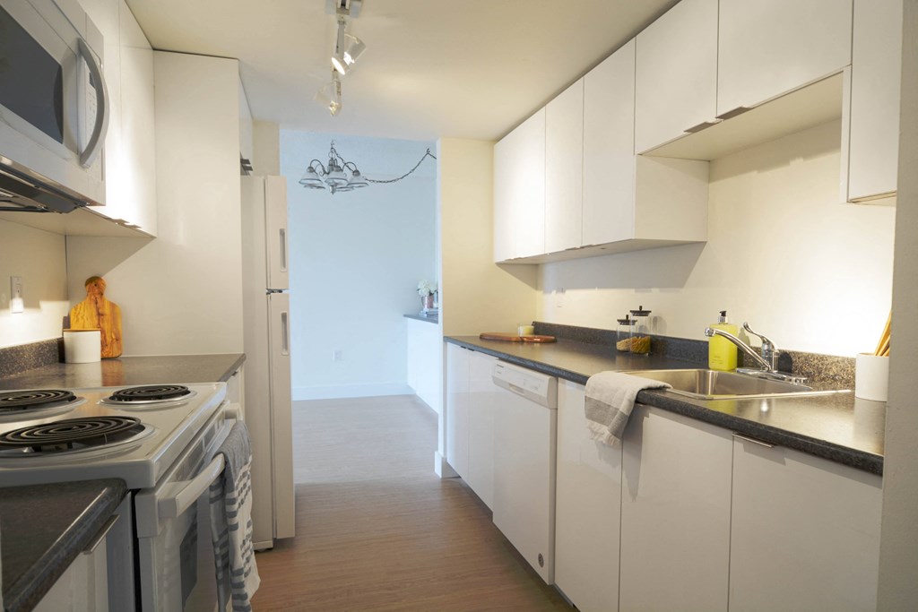 a kitchen with white cabinets and a stove and a sink