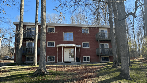 a red brick building with two trees in front of it