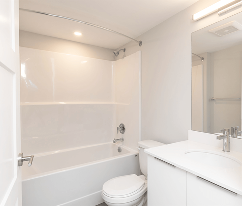 A white bathroom with a toilet, sink, and bathtub.