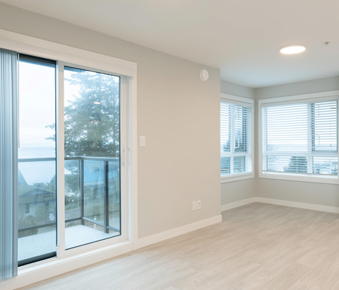 A room with a sliding glass door and a window with blinds.